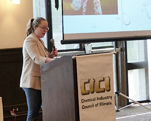 Woman standing at podium holding microphone